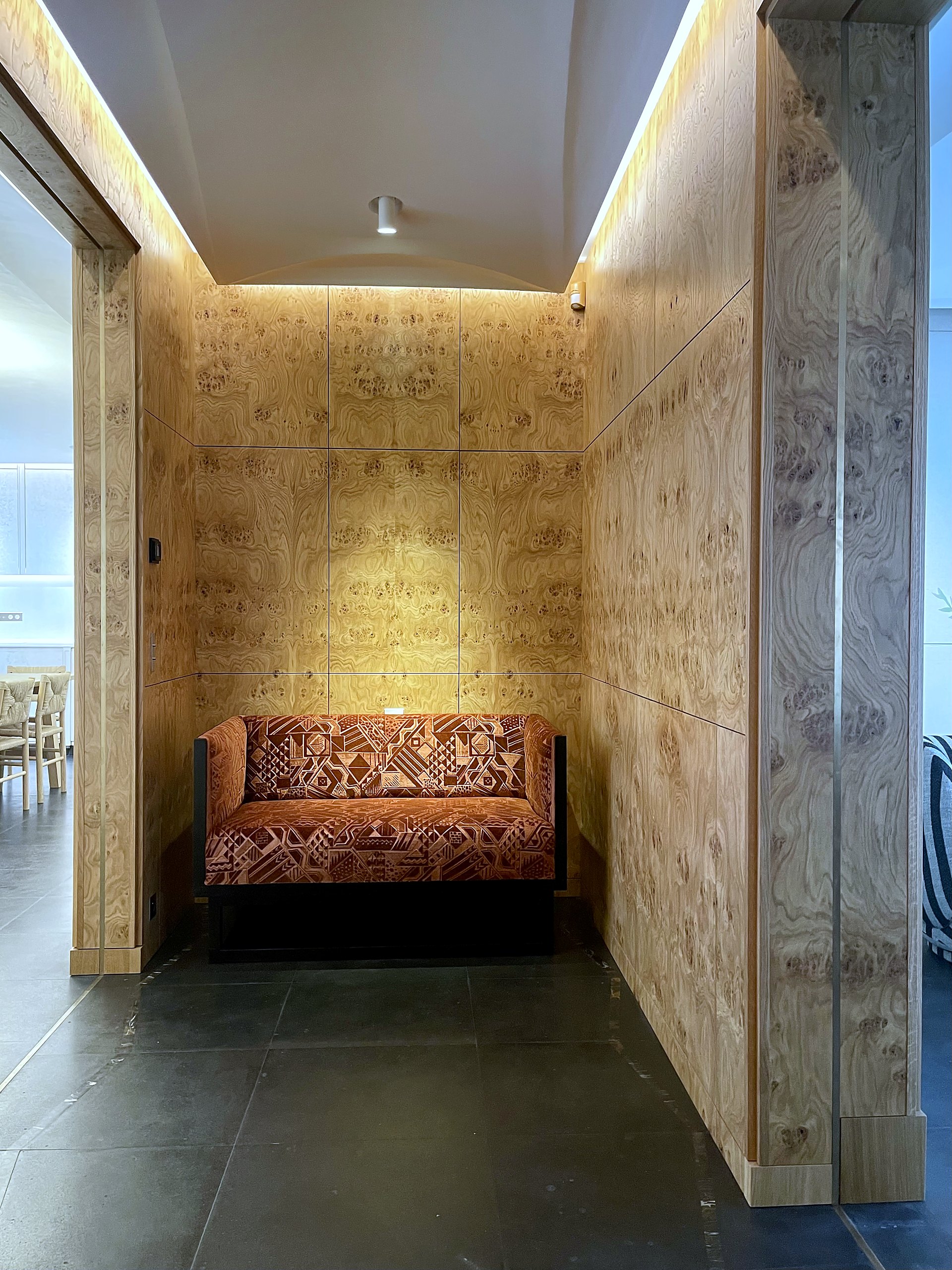 Vestibule, habillages muraux en loupe de chêne, banquette
