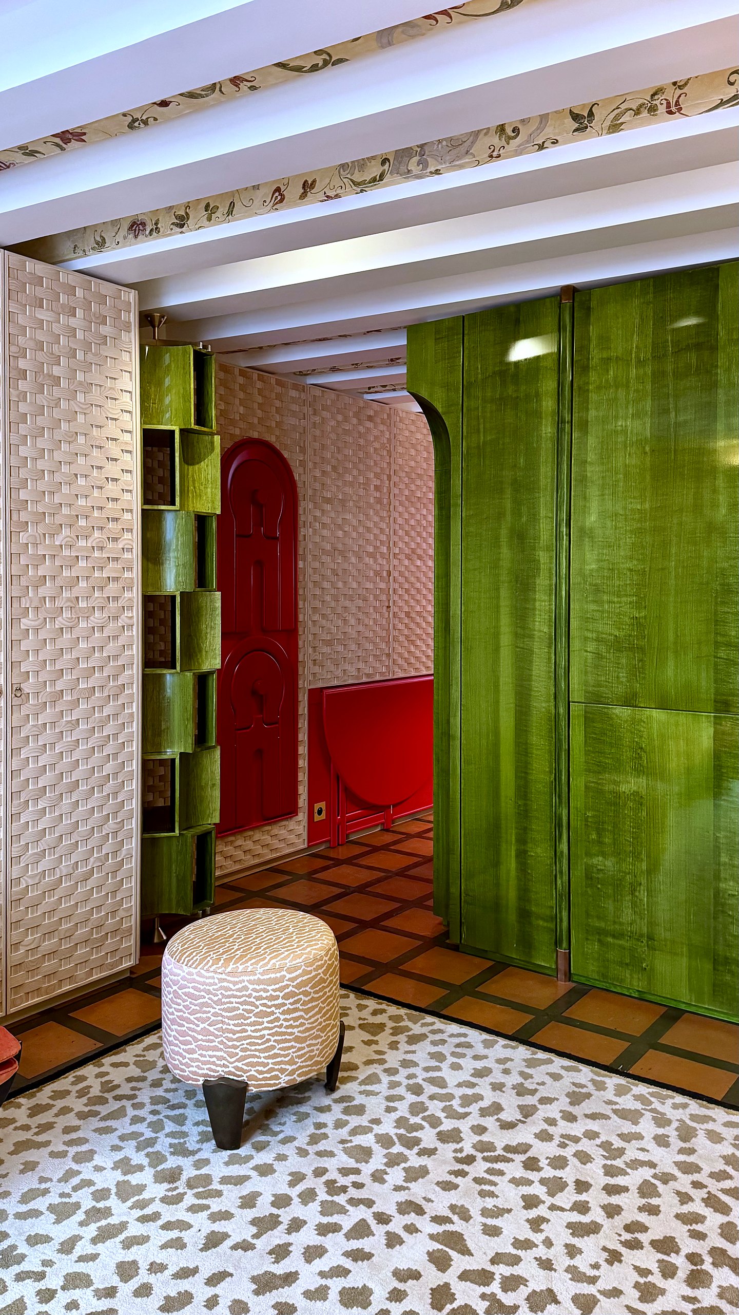 Chaises Tallon suspendues au mur et table basculante en laque rouge satinée, agencement d'un pied-à-terre de 25 m²