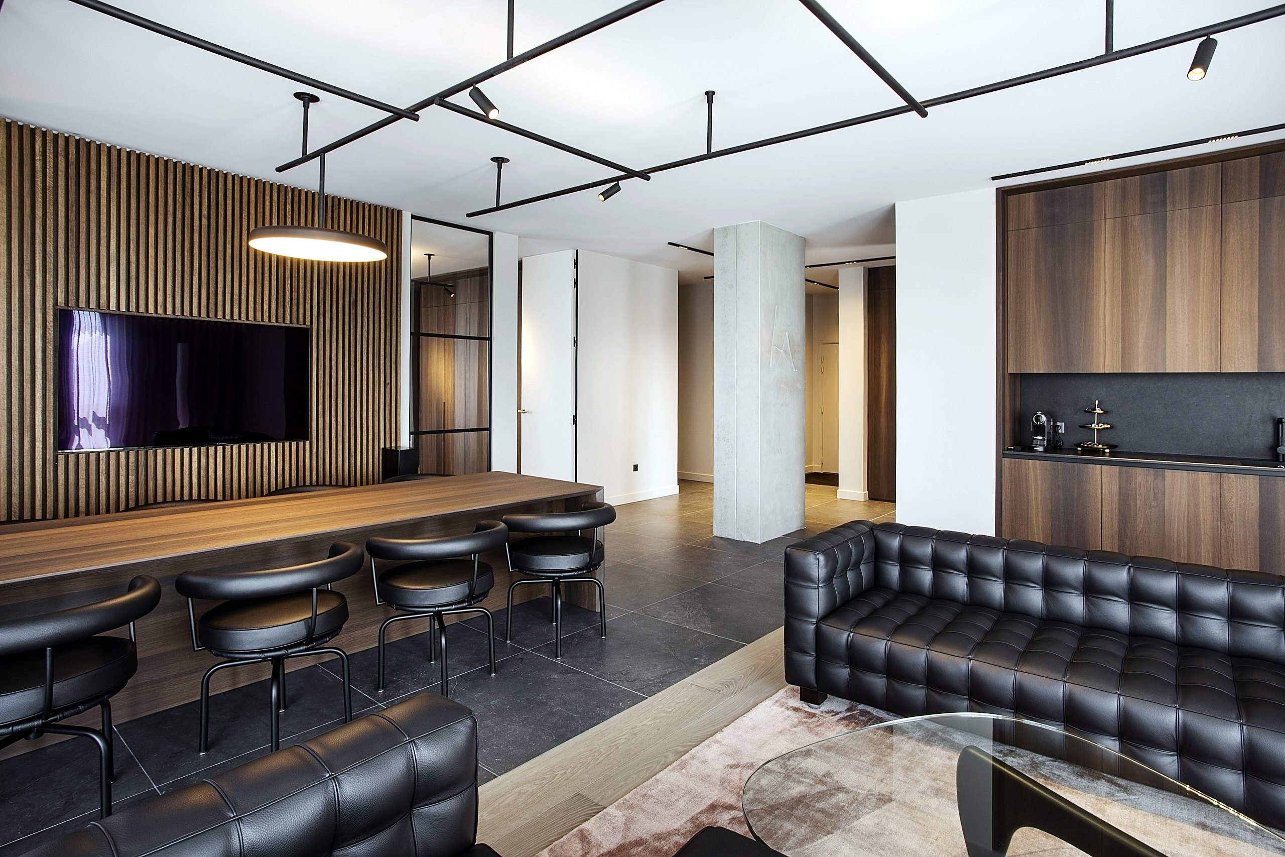Réception de bureaux — agencement en chêne fumé, claustra à tasseaux, mobilier en cuir noir